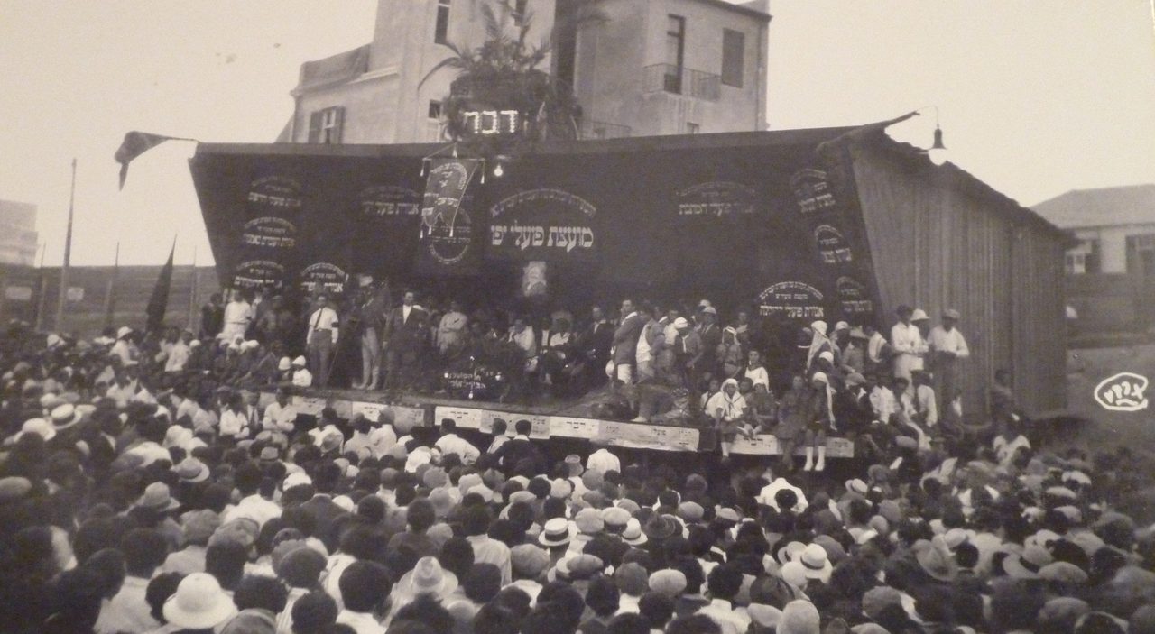 בתמונה: אסיפת אחד במאי השנה (1926), במגרש בית העם בתל אביב. צילם שמעון קורבמן | מקור: הצפירה, ארכיון העיתונות